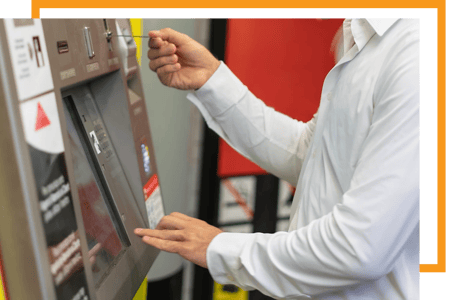 Usuario final introduciendo un ticket en una máquina expendedora